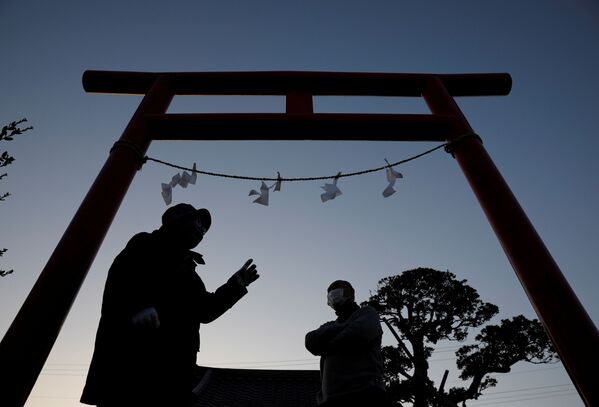 福島県いわき市の秋葉神社にある東日本大震災追悼伝承之碑の鳥居前に立つ住民（2021年3月11日） - Sputnik 日本