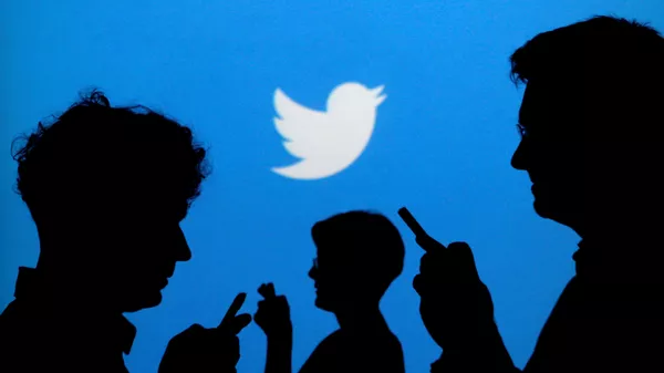 Люди со смартфонами на фоне логотипа Twitter - Sputnik 日本