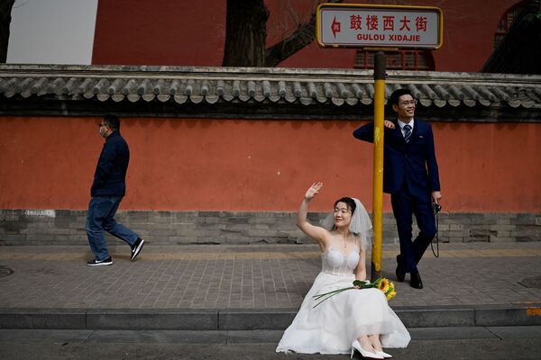 中国・北京で、鐘鼓楼の前で結婚式の前撮り写真を撮るカップル - Sputnik 日本