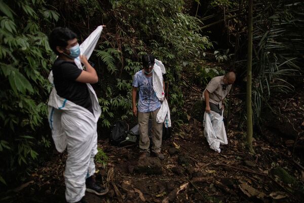 フィリピン・ラグナ州にあるマキリン山で、コウモリの曝露を防ぐため防護服に着替えるウイルスハンターたち - Sputnik 日本