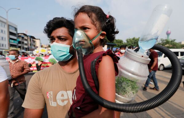 スリランカのコロンボで行われた政府の森林伐採行為に抗議するデモで、酸素マスクをつけて参加する少女 - Sputnik 日本