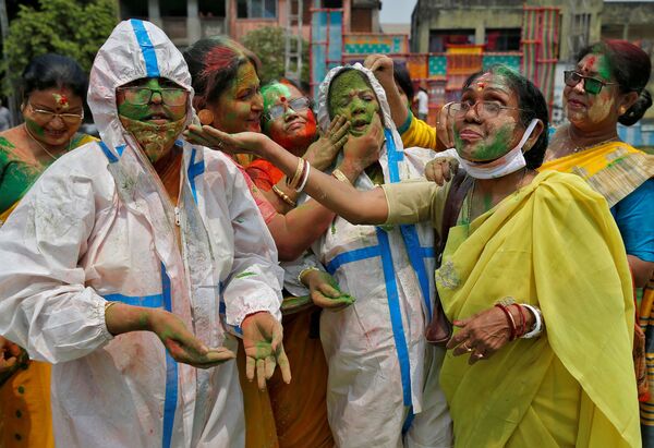 インド・コルカタで行われた「ホーリー祭」で、防護服を着た人にカラーパウダーを塗る人々 - Sputnik 日本