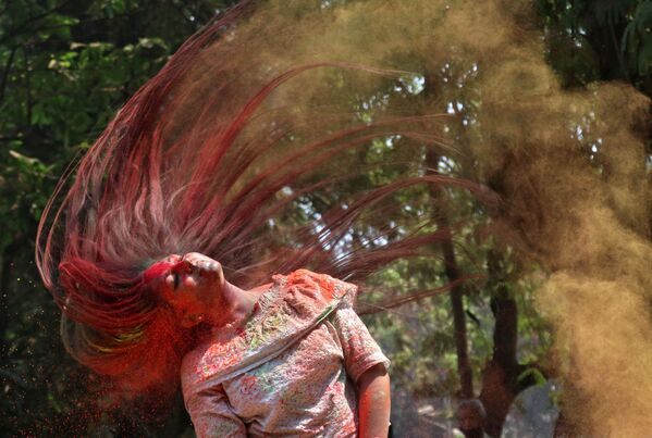 インドのムンバイで行われた「ホーリー祭」で、髪の毛についた粉を振り落とす女性 - Sputnik 日本