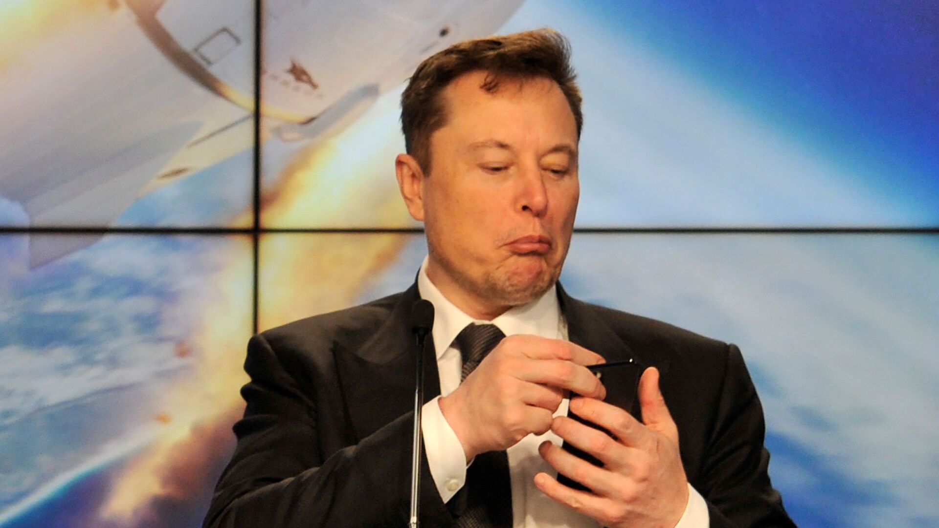 Основатель компаний Tesla и SpaceX Илон Маск с телефоном в руках - Sputnik 日本, 1920, 23.01.2022