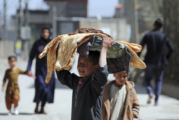 アフガニスタン・カブールでパンを頭の上にのせて歩く少年 - Sputnik 日本