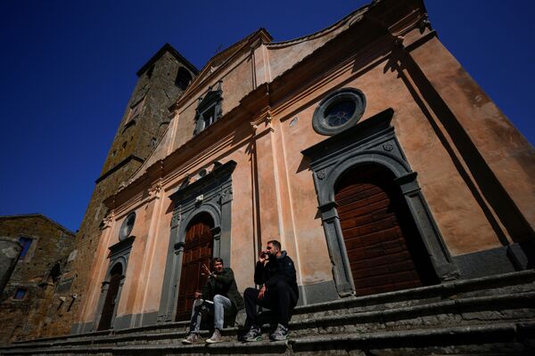 チヴィタ・ディ・バーニョレージョにある教会の前に座る人々 - Sputnik 日本