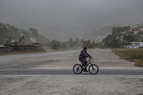 スフリエール火山噴火の翌日、首都キングスタウンの火山灰に覆われた畑を自転車で走る男性 - Sputnik 日本