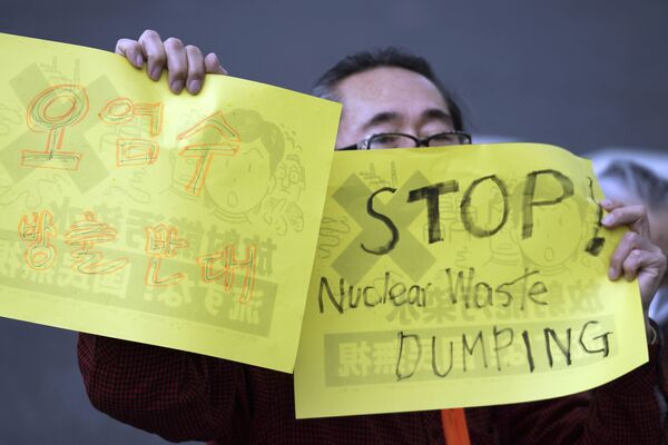 福島第一原発の処理水の海洋放出が決定したことを受け、東京都千代田区の首相官邸前で行われた抗議デモで、プラカードを掲げる男性 - Sputnik 日本