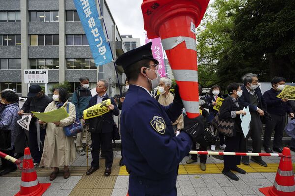 福島第一原発の処理水の海洋放出が決定したことを受け、東京都千代田区の首相官邸前で行われた抗議デモで、コーンを持ち上げる警察官 - Sputnik 日本