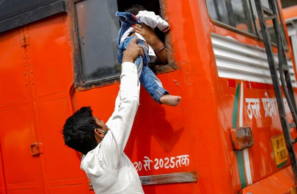 1週間のロックダウン（都市封鎖）が導入されるインド・ニューデリーで、自分の子どもを窓からバスに乗せる出稼ぎ労働者 - Sputnik 日本