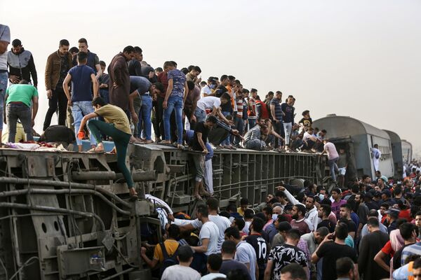 エジプト・トゥーク市で発生した列車脱線事故の現場で、横転した列車に登る人々 - Sputnik 日本