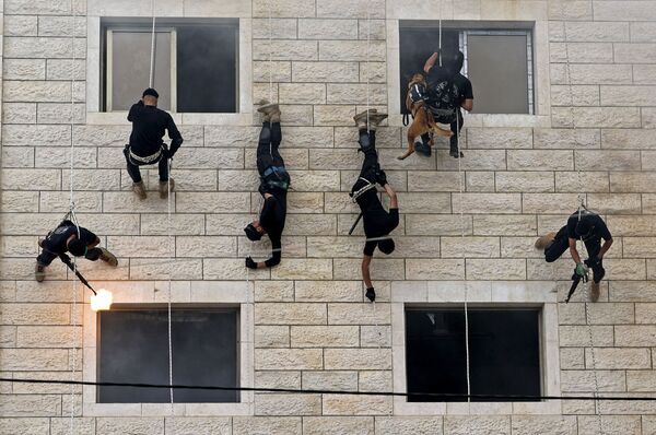 パレスチナ自治区・ガザ地区で行われた警察学校の卒業式で、建物の壁を懸垂下降する「ハマス」の治安部隊 - Sputnik 日本