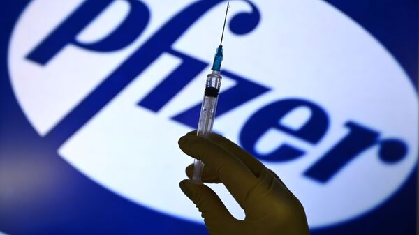 A syringe in front of the Pfizer logo. - Sputnik 日本