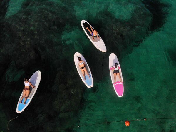 レバノン・バトラウンの地中海沿岸で、ボードに乗ってヨガの練習をする女性ら - Sputnik 日本