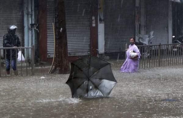 大型サイクロンが直撃したインド・ムンバイの路上で、飛ばされた傘を見つめる女性 - Sputnik 日本
