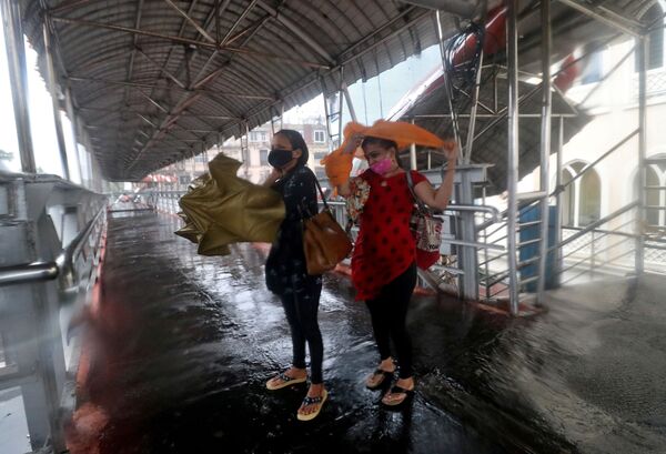 大型サイクロンが直撃したインド・ムンバイで、大雨が降る中横断歩道橋に避難する女性たち - Sputnik 日本
