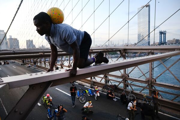 フロイドさんの死から1年を迎えた25日、ニューヨーク市のブルックリン橋を行進中に橋の上でポーズをとるBLM運動支持者 - Sputnik 日本