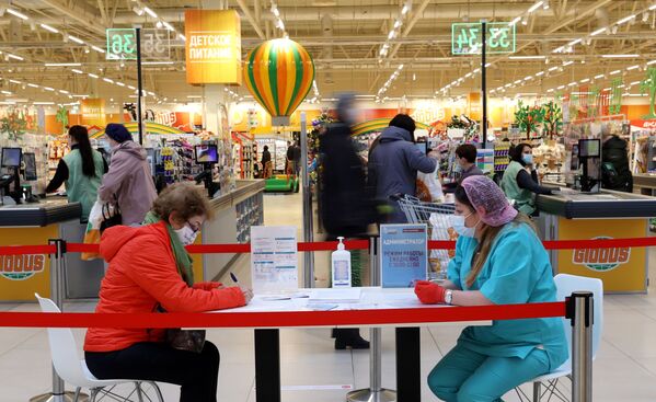 ロシア・モスクワの大型スーパーマーケットで、ワクチン接種のための書類を記入する女性 - Sputnik 日本