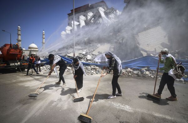 パレスチナ自治区ガザ地区で、イスラエル軍の攻撃で崩壊した高層ビル「ハナディ・タワー」の瓦礫を片付けるボランティアと市職員ら - Sputnik 日本
