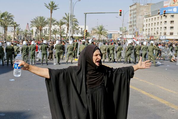 イラク・バグダッドで、反政府デモの参加者らにジェスチャーを送る女性 - Sputnik 日本