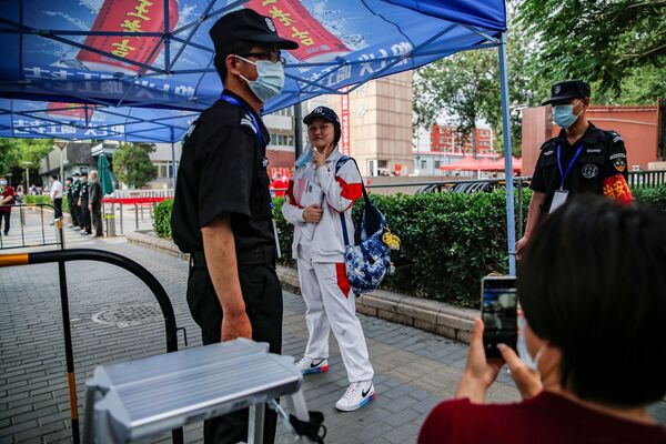 北京市で、統一大学入試「高考」の試験会場に入る前、親に向かってポーズをとる受験生 - Sputnik 日本