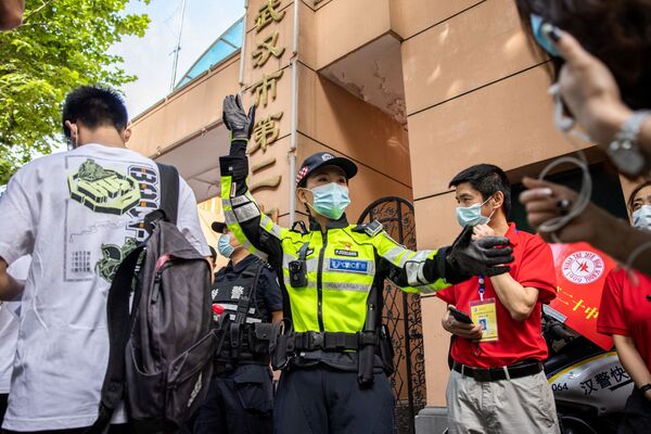 武漢市で、統一大学入試「高考」の試験会場に到着する受験生を見守る警察官 - Sputnik 日本