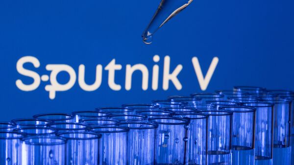 est tubes are seen in front of a displayed Sputnik V logo in this illustration taken, May 21, 2021. - Sputnik 日本