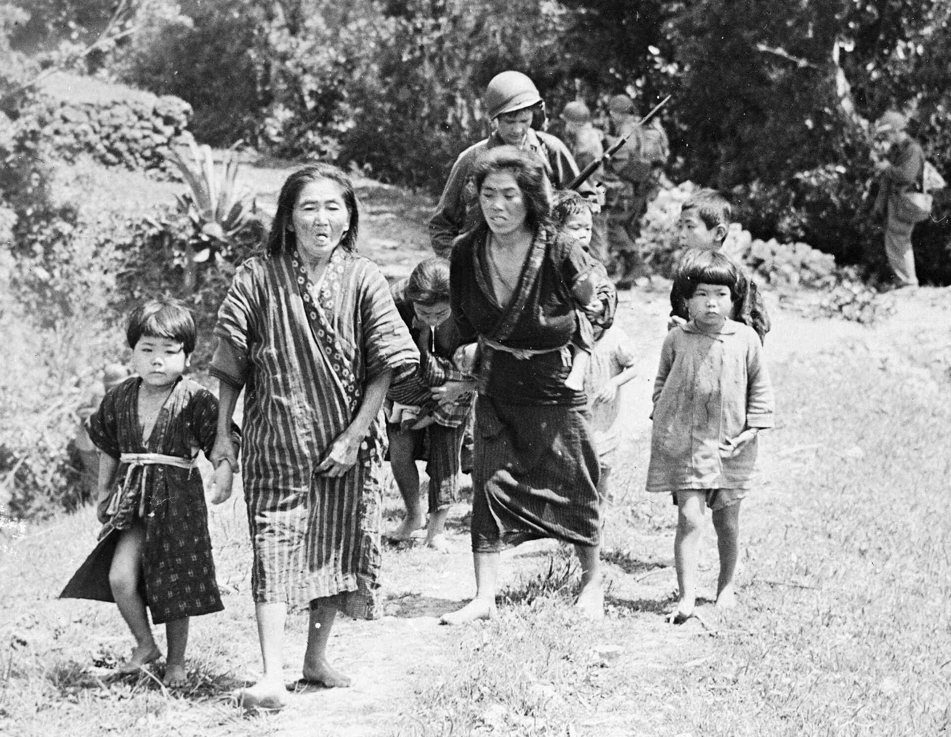 Японские женщины и дети идут по дороге Окинавы после вторжения американских войск на остров Рюкю, 1945 год - Sputnik 日本, 1920, 07.02.2023