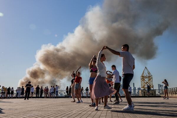 ロシア・モスクワで、花火倉庫の火災で煙が上がる中サンバを踊る男女 - Sputnik 日本