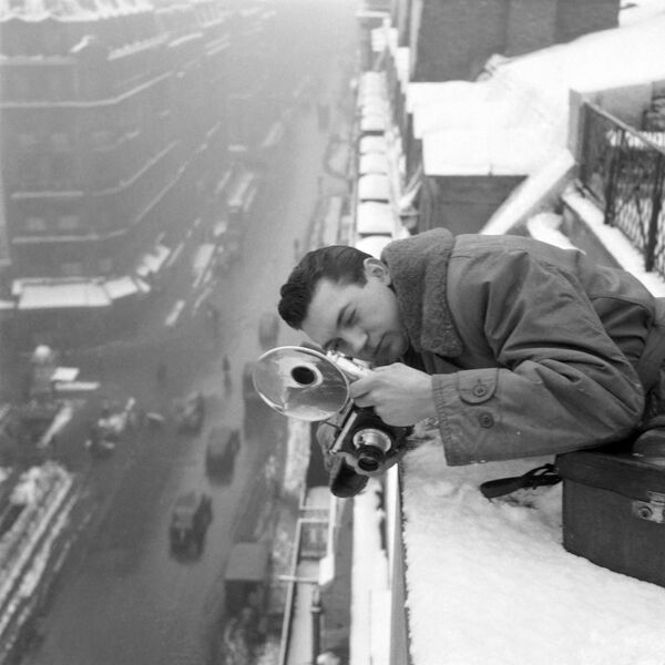 フランス・パリで、雪が積もる屋根の上で写真を撮るAFP通信のカメラマン - Sputnik 日本