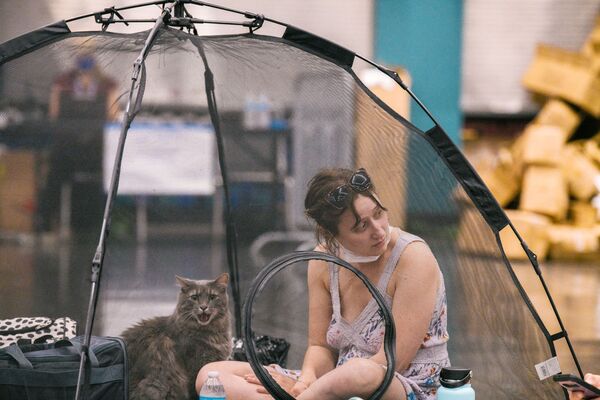米オレゴン州で、クーリングセンターのテントの中で飼い猫と一緒に一休みする女性 - Sputnik 日本