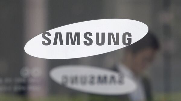 Сотрудник проходит мимо логотипа Samsung в Сеуле, Южная Корея - Sputnik 日本