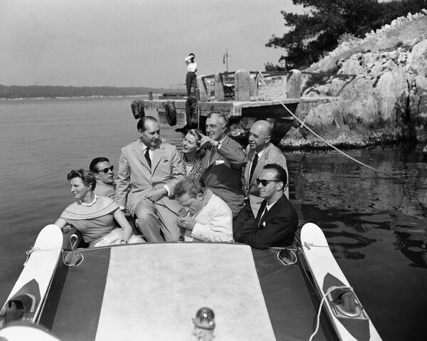 第9回映画祭で、昼食会の後ボートで出発するイタリアの映画監督ロベルト・ロッセリーニ氏と妻で女優イングリッド・バーグマン（中央）（1956年5月9日） - Sputnik 日本
