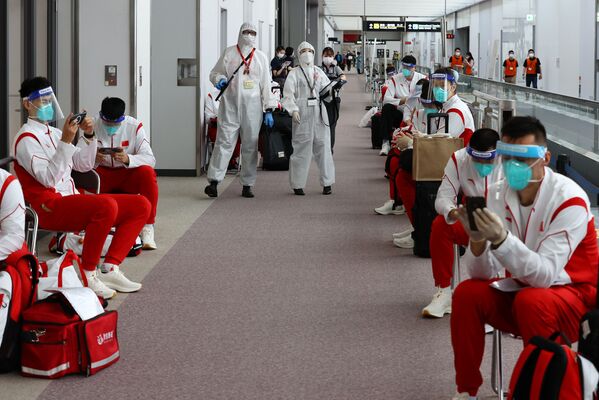 成田空港に到着した中国選手団と防護服を着た検疫官 - Sputnik 日本