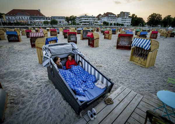 ドイツ・トラフェミュンデで、ビーチに設置されたビーチチェアで夜を過ごす準備をする女性たち - Sputnik 日本