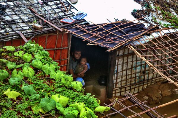 バングラデシュ・クトゥパロンにあるロヒンギャ難民キャンプで、大雨で浸水する中で子どもを抱える男性 - Sputnik 日本