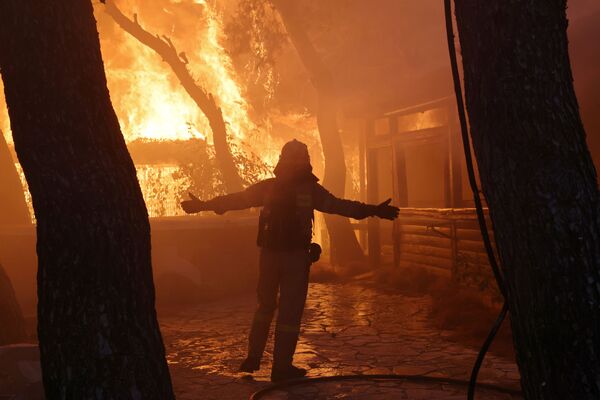 森林火災が発生したギリシャ・アテネ北部で、火災現場に立つ消防隊員 - Sputnik 日本
