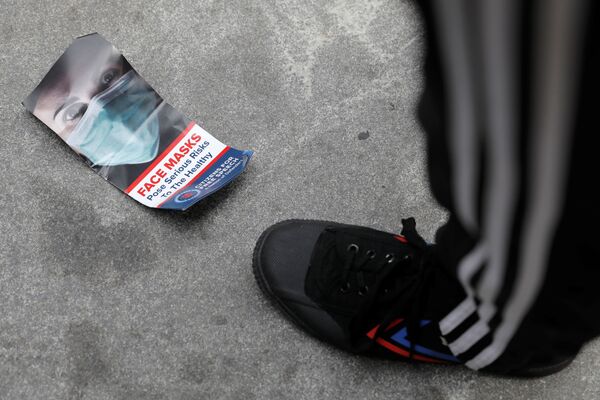 マンハッタンのニューヨーク市庁舎前で行われたワクチンの義務化反対デモで、地面に捨てられたマスクに関するパンフレット - Sputnik 日本
