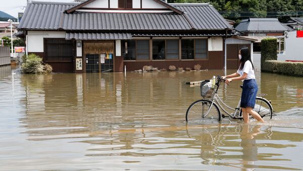 佐賀県武雄市で、冠水した道路を自転車で進む女性 - Sputnik 日本