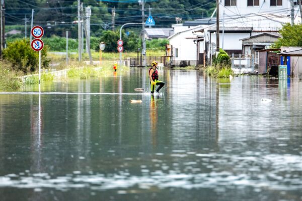 佐賀県武雄市で、冠水した道路をかき分けて進む消防署員 - Sputnik 日本