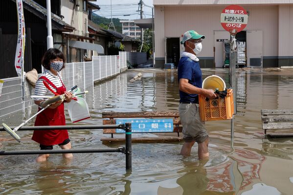 佐賀県武雄市で、冠水した道路を荷物を持って歩く地元住民ら - Sputnik 日本