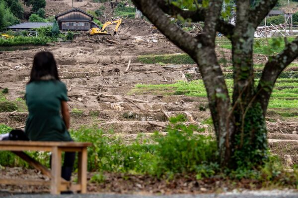 佐賀県武雄市で、土砂崩れの現場で瓦礫が撤去される様子を見守る女性 - Sputnik 日本