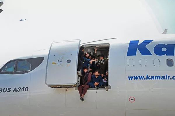カブール国際空港で、飛行機に乗り込み扉のそばに座るアフガニスタン人ら カブール国際空港で、飛行機に乗り込み扉のそばに座るアフガニスタン人ら - Sputnik 日本