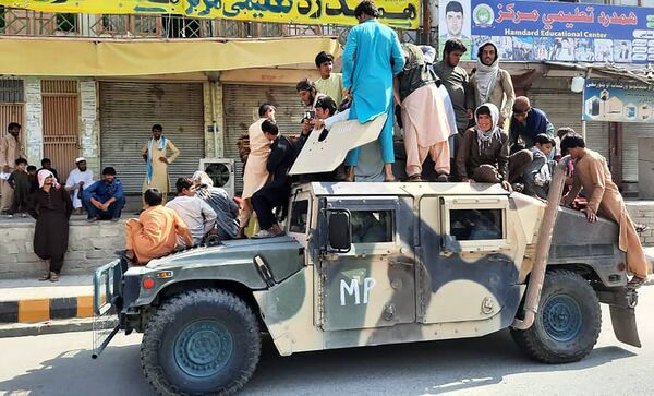 ラグマン州の道端に置かれたアフガニスタン軍（ANA）のHMMWV（ハンヴィー、高機動多用途装輪車両）にのぼるタリバン戦闘員と地元住民ら - Sputnik 日本