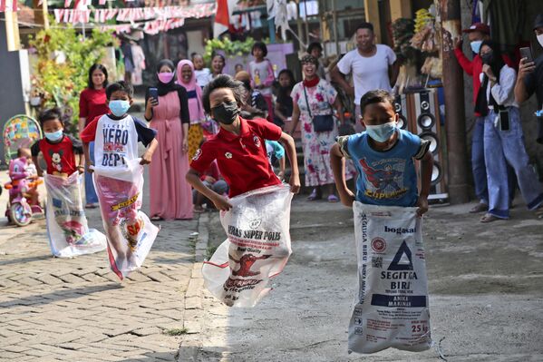 インドネシア・ジャカルタで開催された独立記念日の祝賀イベントで、マスクをつけてサックレースに参加する子どもたち - Sputnik 日本