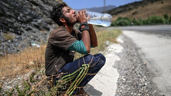 Афганский мигрант пьет воду в Татване - Sputnik 日本