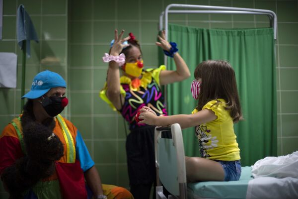 キューバ・ハバナで、新型コロナウイルスワクチンの接種を受けた少女を楽しませるピエロ - Sputnik 日本