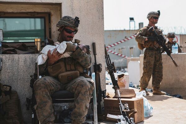 アフガニスタン・カブールにあるハミド・カルザイ国際空港で、避難中の赤ちゃんを抱く米海兵隊員 - Sputnik 日本