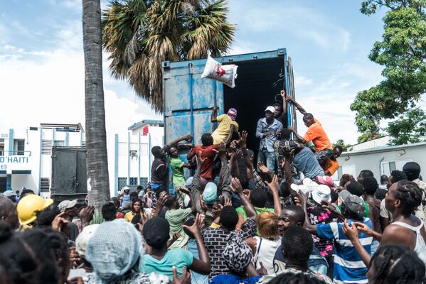 ハイチ・レカイで、地震の被災者にトラックから米袋を投げおろす男性 - Sputnik 日本