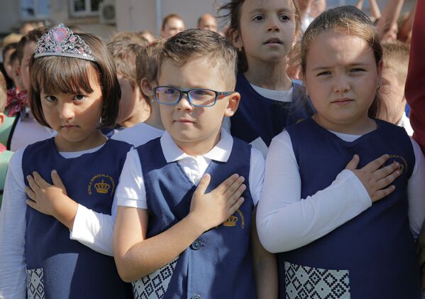ルーマニア・ブカレストの学校で行われた新学期を祝うお祭りで、国歌が流れる中、胸に手を当てる児童ら - Sputnik 日本